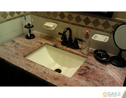 3046 Cheesequake Road Old Bridge, NJ 08859 - Photo 8 of 16 a bathroom with a sink and mirror