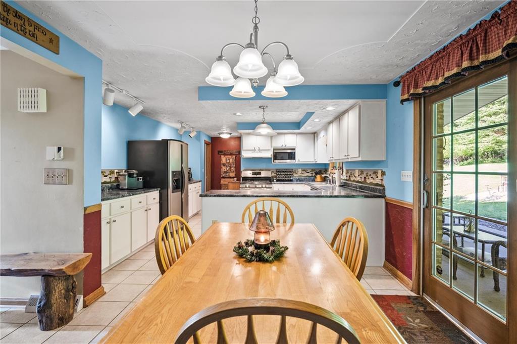 206 Harbison Road Sarver, PA 16055 - Photo 6 of 46 a dining room with stainless steel appliances granite countertop a dining table chairs and a chandelier