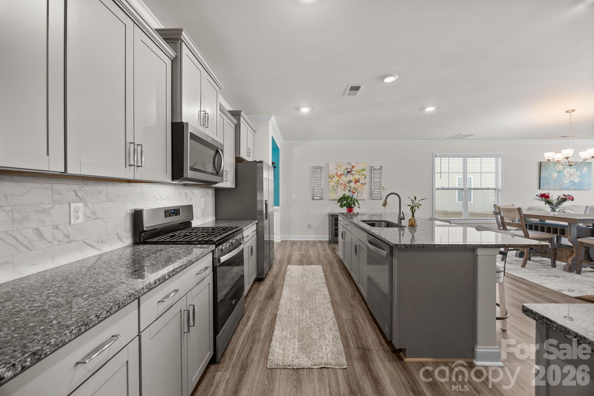 7895 Iron Road Sherrills Ford, NC 28673 - Photo 8 of 38 a open kitchen with stainless steel appliances granite countertop a stove top oven a sink dishwasher and cabinets with wooden floor