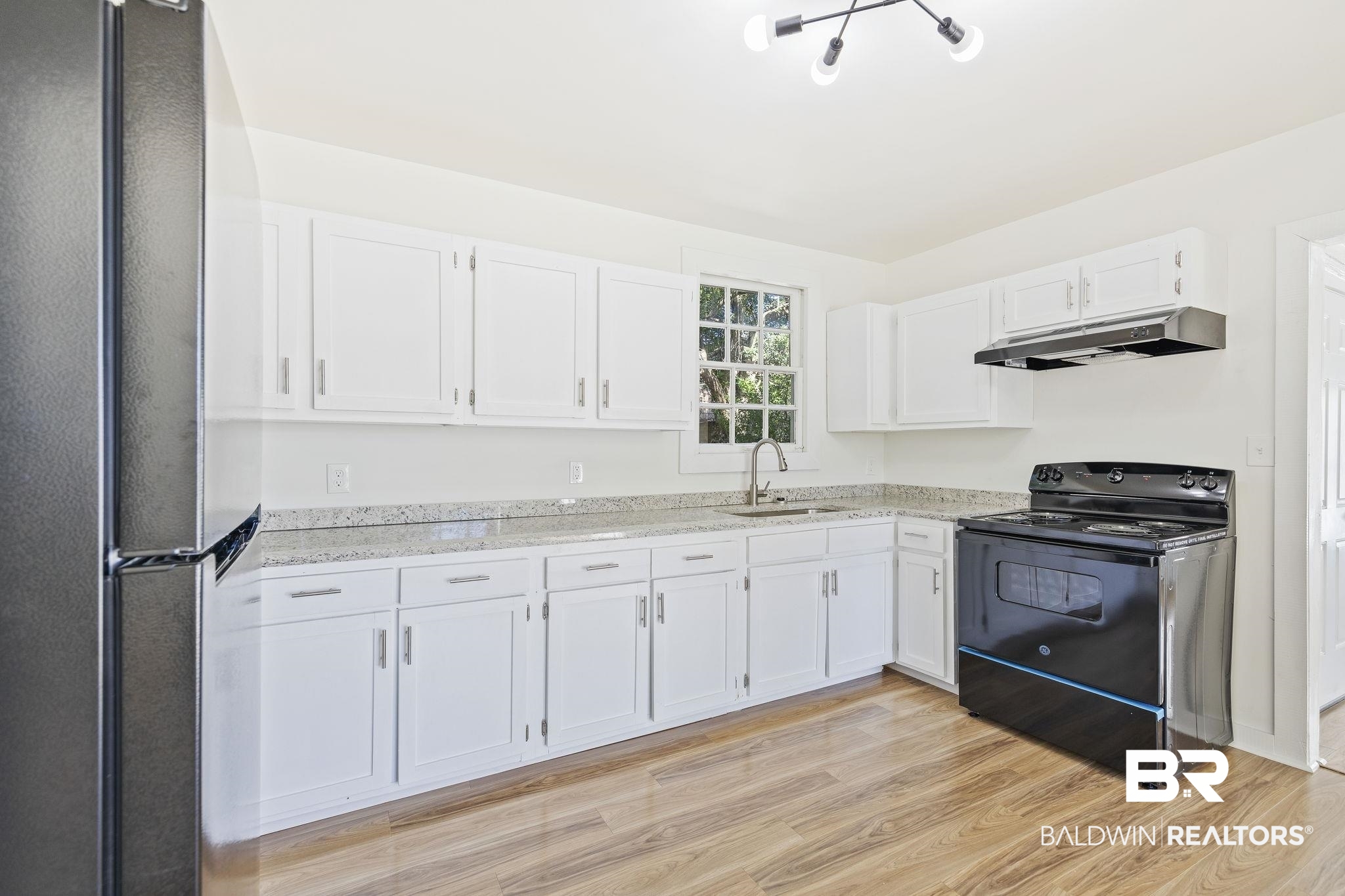 1400 North Cloverleaf Circle Mobile, AL 36605 - Photo 5 of 17 Kitchen with sink, light wood-type flooring, white cabinets, black / electric stove, and stainless steel refrigerator