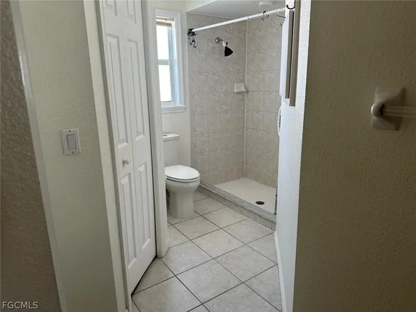 a bathroom with a granite countertop toilet and a shower