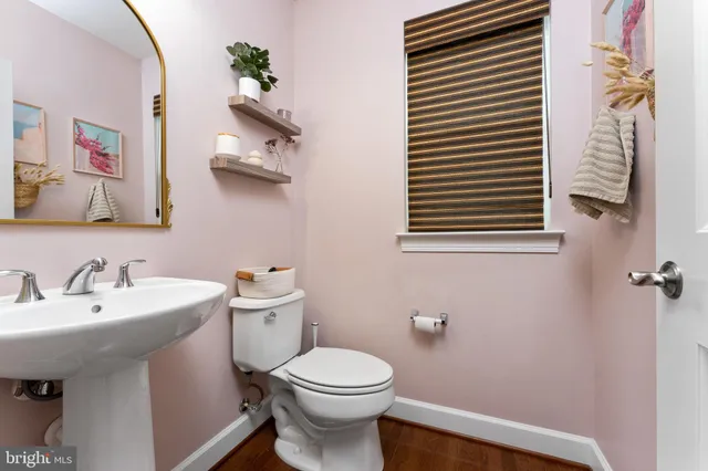 a bathroom with a toilet a sink and mirror
