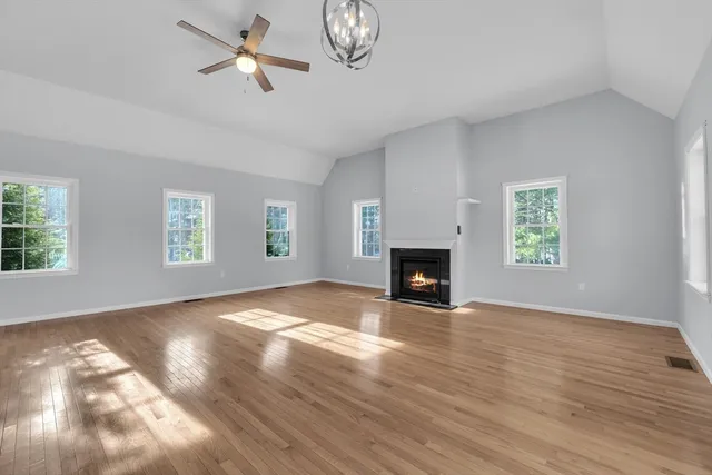 a view of empty room with wooden floor and fireplace