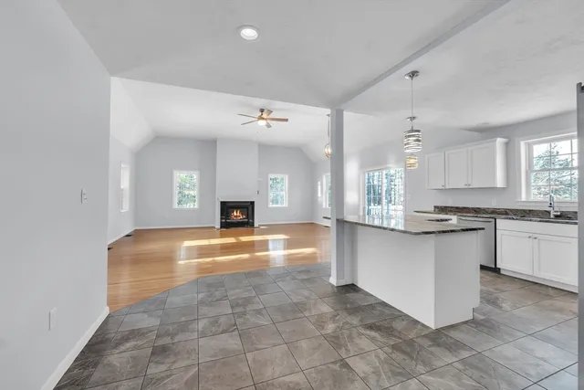 a large kitchen with kitchen island a counter top space a sink stainless steel appliances and cabinets
