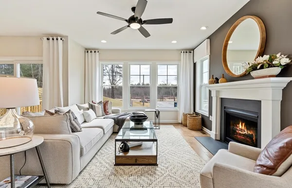 a living room with furniture a large window and a fireplace