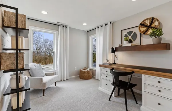 a view of a workspace with furniture and a window