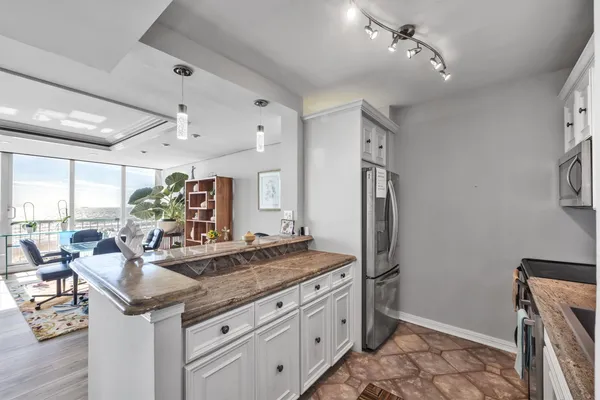 a kitchen with granite countertop a sink appliances and cabinets