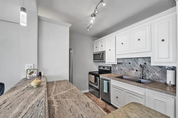 a kitchen with a sink stove and cabinets