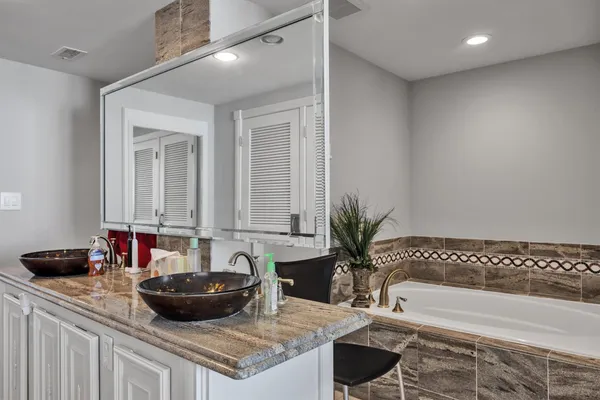 a bathroom with a granite countertop tub and a sink