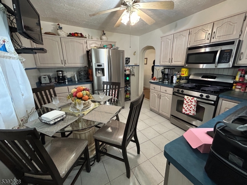 63 Grant Avenue East Hanover, NJ 07936 - Photo 4 of 19 a kitchen with stainless steel appliances a stove a sink dishwasher a dining table and chairs with wooden floor