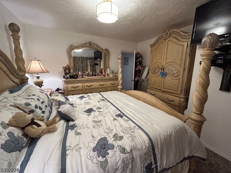 63 Grant Avenue East Hanover, NJ 07936 - Photo 9 of 19 a bedroom with a bed and a mirror on dresser