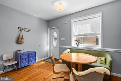 a view of a dining room with furniture a rug and wooden floor