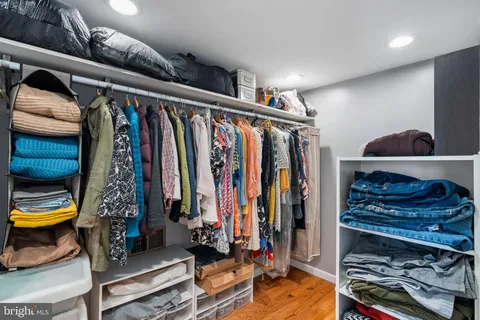 a view of walk in closet with clothes and shoes