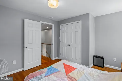 a bedroom with a bed and painting on the wall