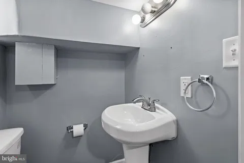 a bathroom with a sink a toilet and a mirror