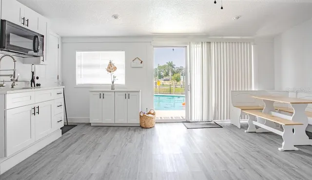 a view of a kitchen with wooden floor and electronic appliances