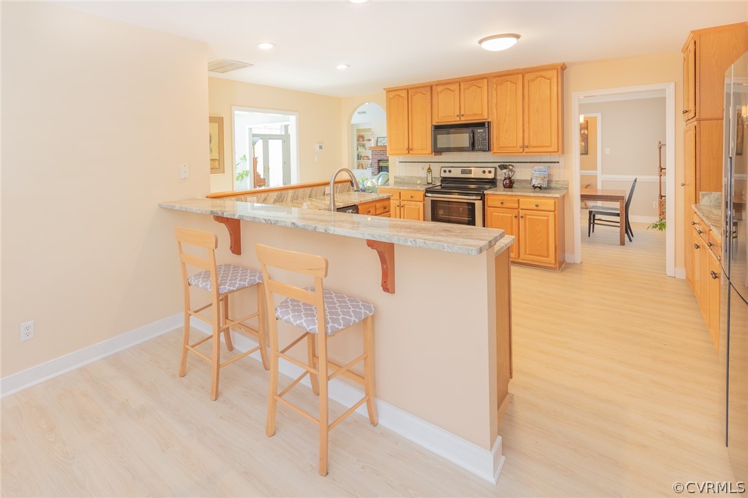 1841 Covington Road Crozier, VA 23039 - Photo 22 of 50 a kitchen with stainless steel appliances a stove a sink a microwave a dining table and chairs