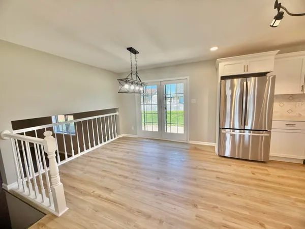 a view of a livingroom with wooden floor and staircase