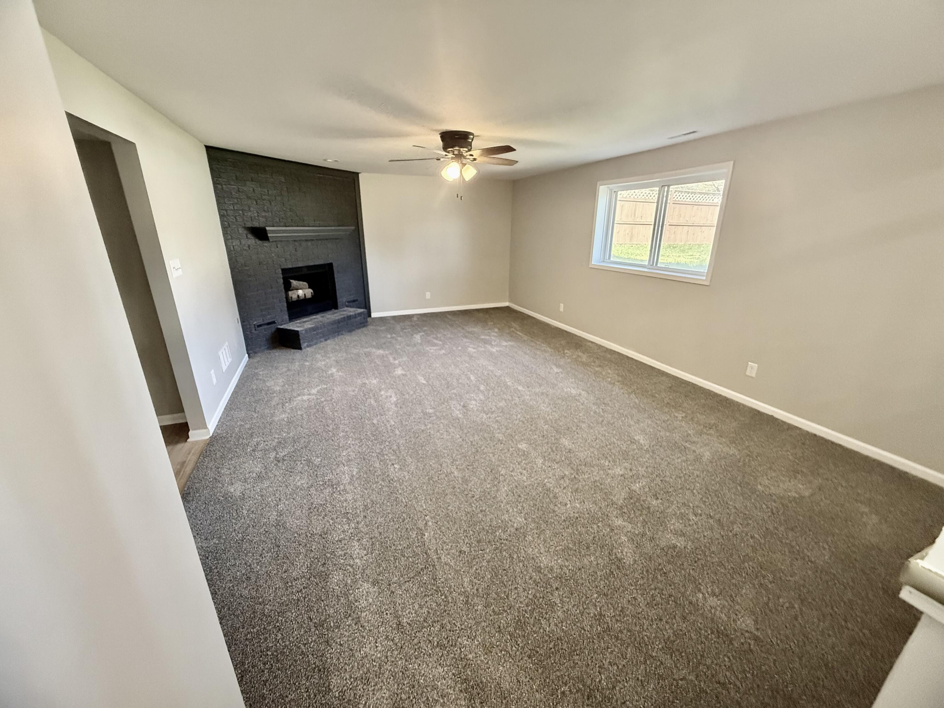 601 Holly Lane Griffith, IN 46319 - Photo 13 of 44 an empty room with windows and a fireplace