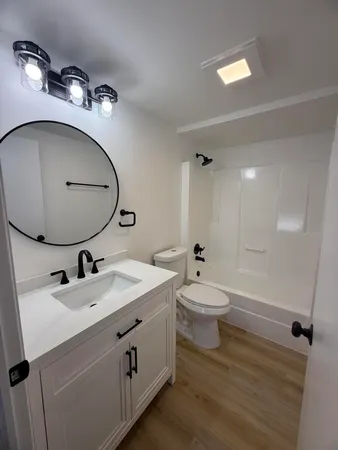 a bathroom with a toilet a sink and mirror