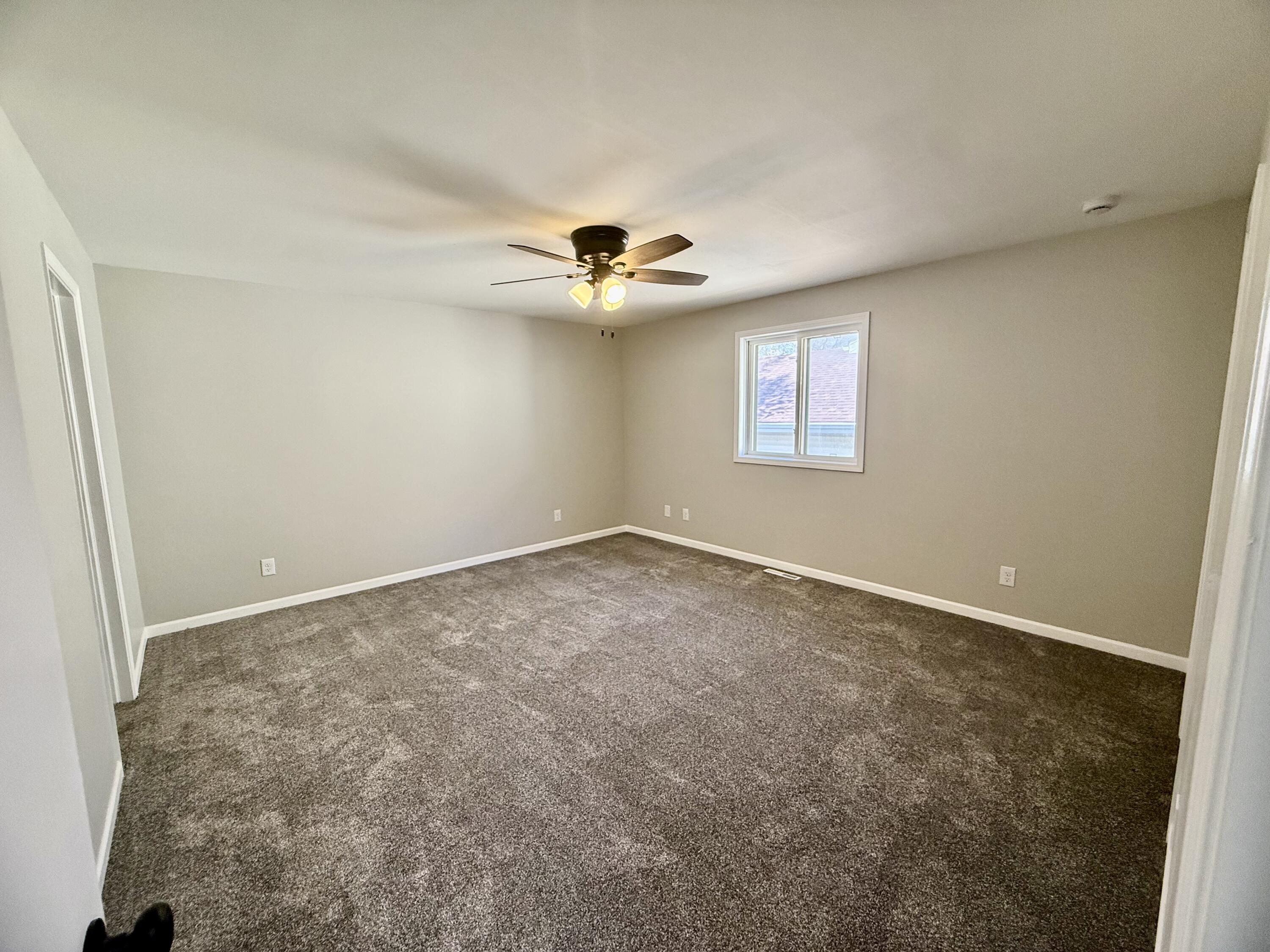 601 Holly Lane Griffith, IN 46319 - Photo 23 of 44 an empty room with windows and chandelier fan