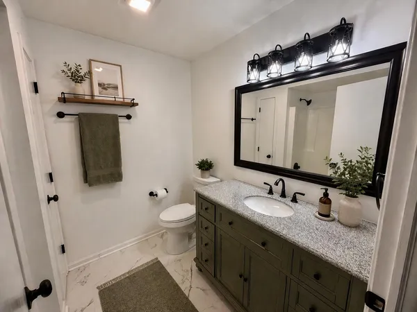 a bathroom with a toilet sink and mirror