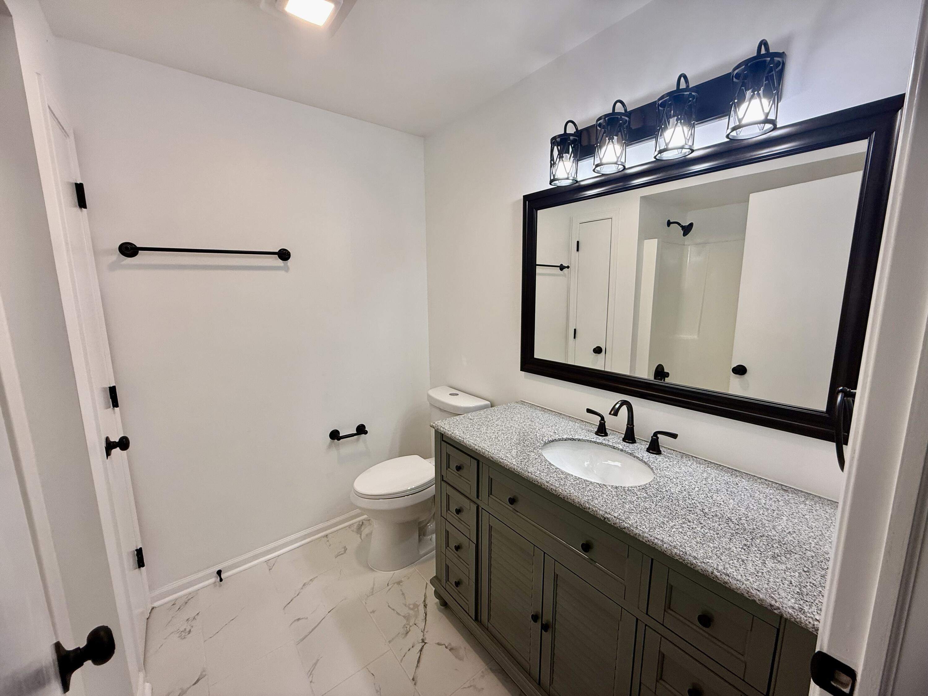 601 Holly Lane Griffith, IN 46319 - Photo 33 of 44 a bathroom with a granite countertop sink toilet and mirror