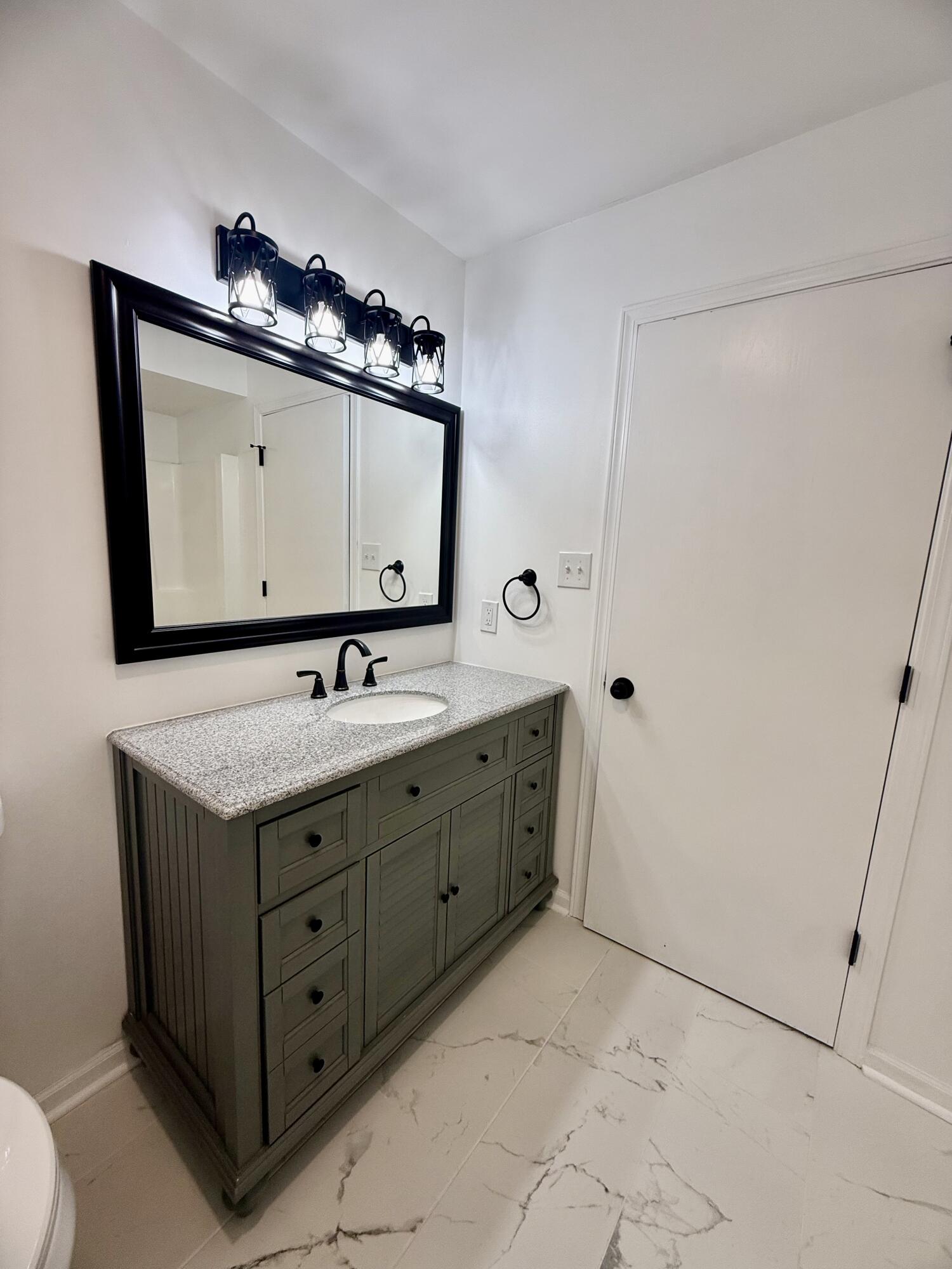 601 Holly Lane Griffith, IN 46319 - Photo 34 of 44 a bathroom with a sink and a mirror