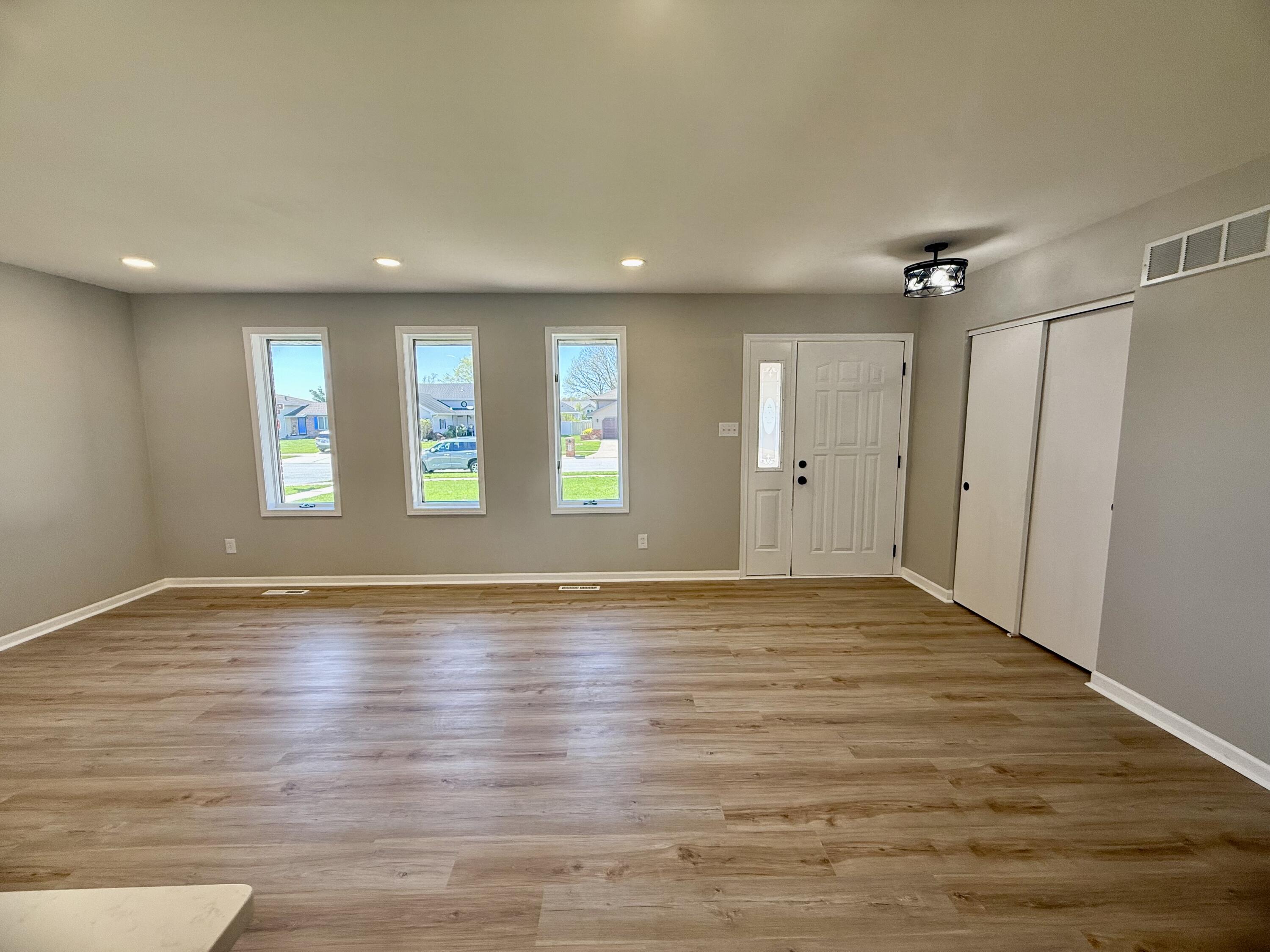 601 Holly Lane Griffith, IN 46319 - Photo 5 of 44 an empty room with wooden floor and windows