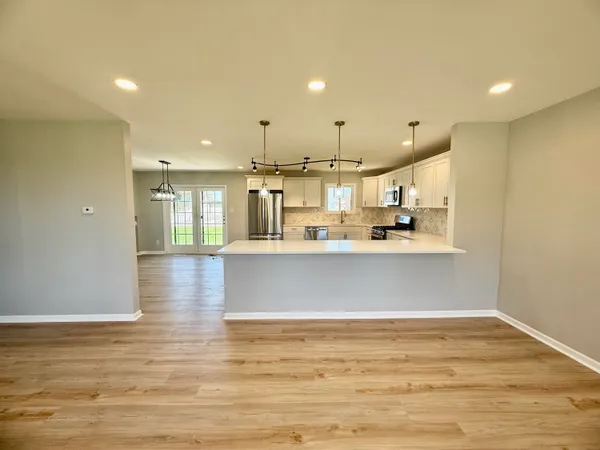 a view of kitchen with kitchen island and stainless steel appliances