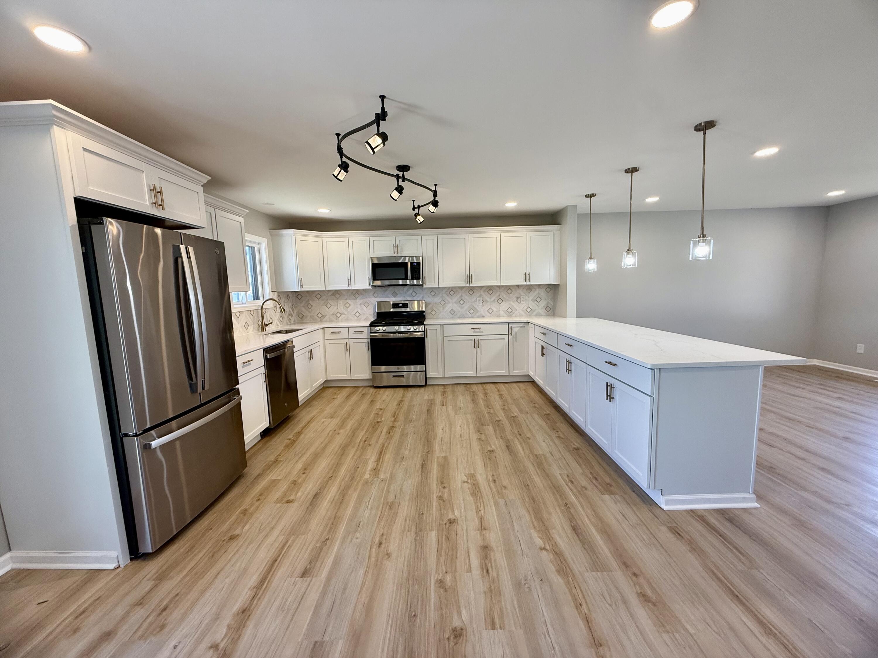 601 Holly Lane Griffith, IN 46319 - Photo 10 of 44 a large kitchen with a center island wooden floor stainless steel appliances and cabinets