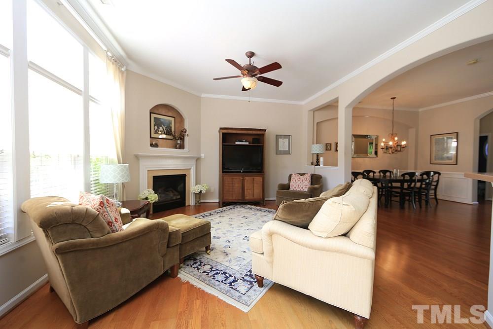 6822 Middleboro Drive Raleigh, NC 27612 - Photo 2 of 13 a living room with furniture a fireplace and a large window