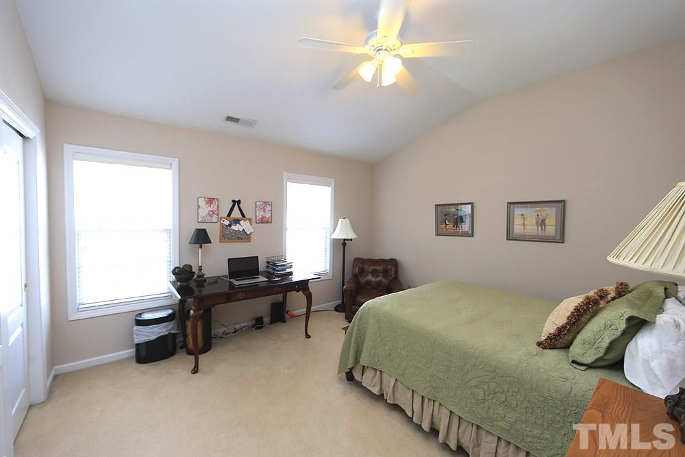 6822 Middleboro Drive Raleigh, NC 27612 - Photo 10 of 13 a bedroom with a bed and a chandelier