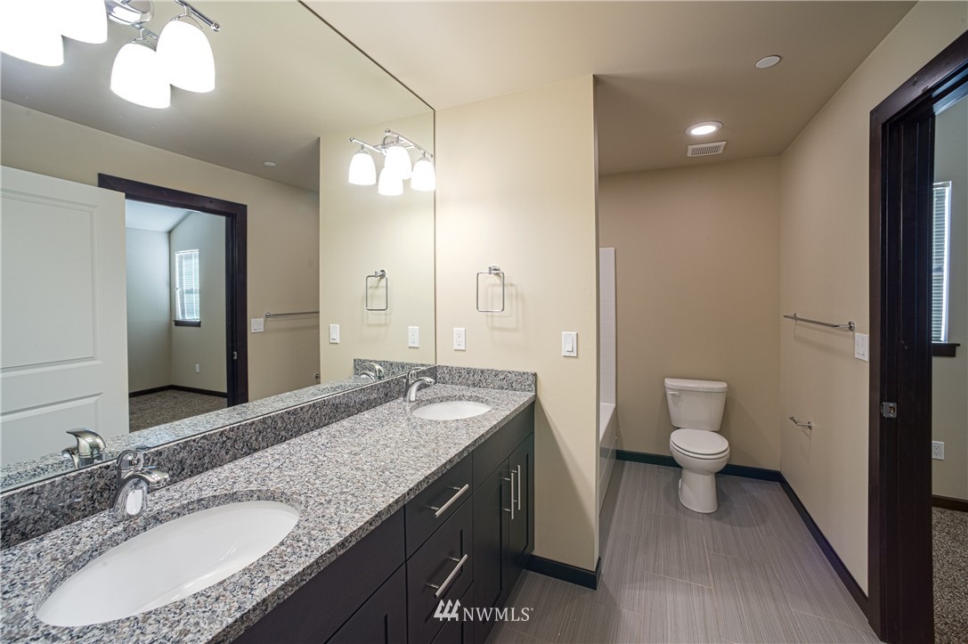 604 Morris Avenue South Renton, WA 98057 - Photo 11 of 21 a bathroom with a granite countertop sink a toilet and a mirror