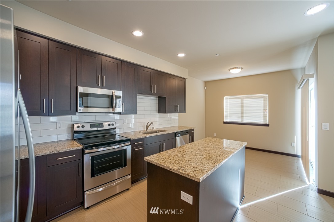 604 Morris Avenue South Renton, WA 98057 - Photo 9 of 21 a kitchen with stainless steel appliances kitchen island granite countertop a stove a sink and a microwave