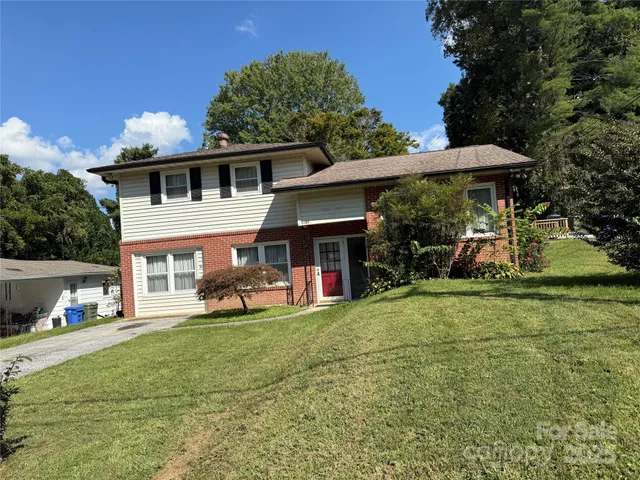 a view of a house with backyard and sitting area