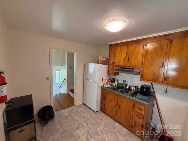 a kitchen with a refrigerator and a stove top oven