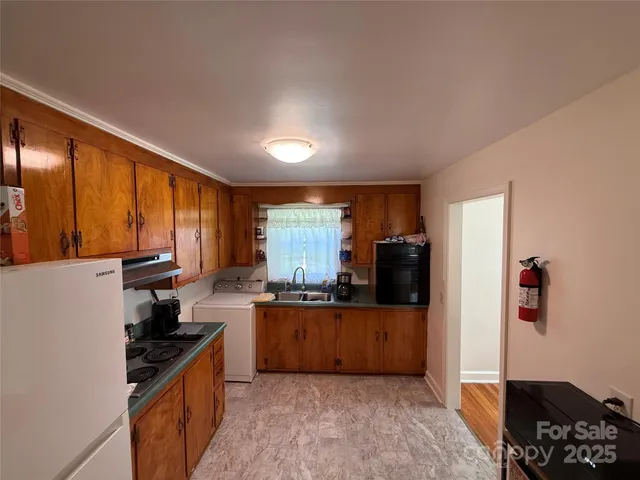 a kitchen with granite countertop a refrigerator stove top oven and sink