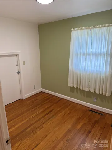 a view of a room with wooden floor and a window