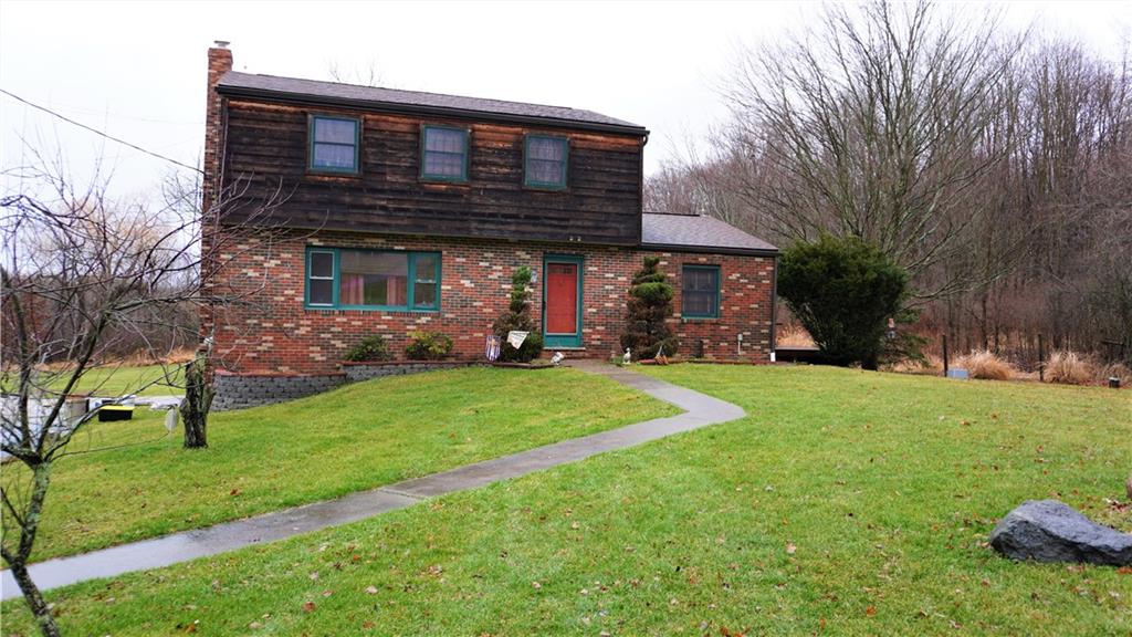 a front view of house with a garden