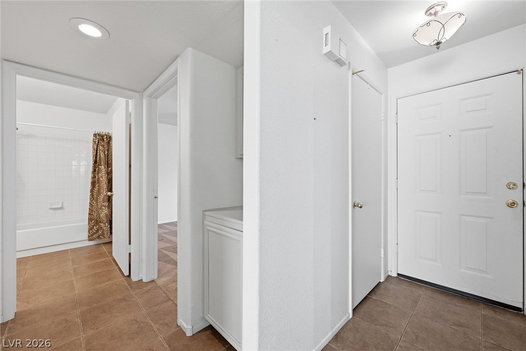 Corridor with light tile patterned flooring