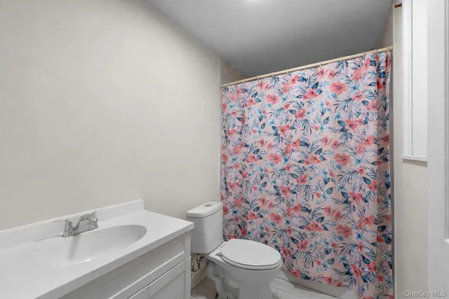 a white toilet sitting next to a shower curtain
