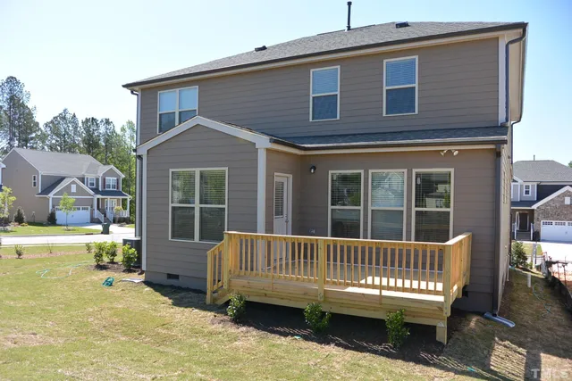 a view of a house with a wooden deck and a yard