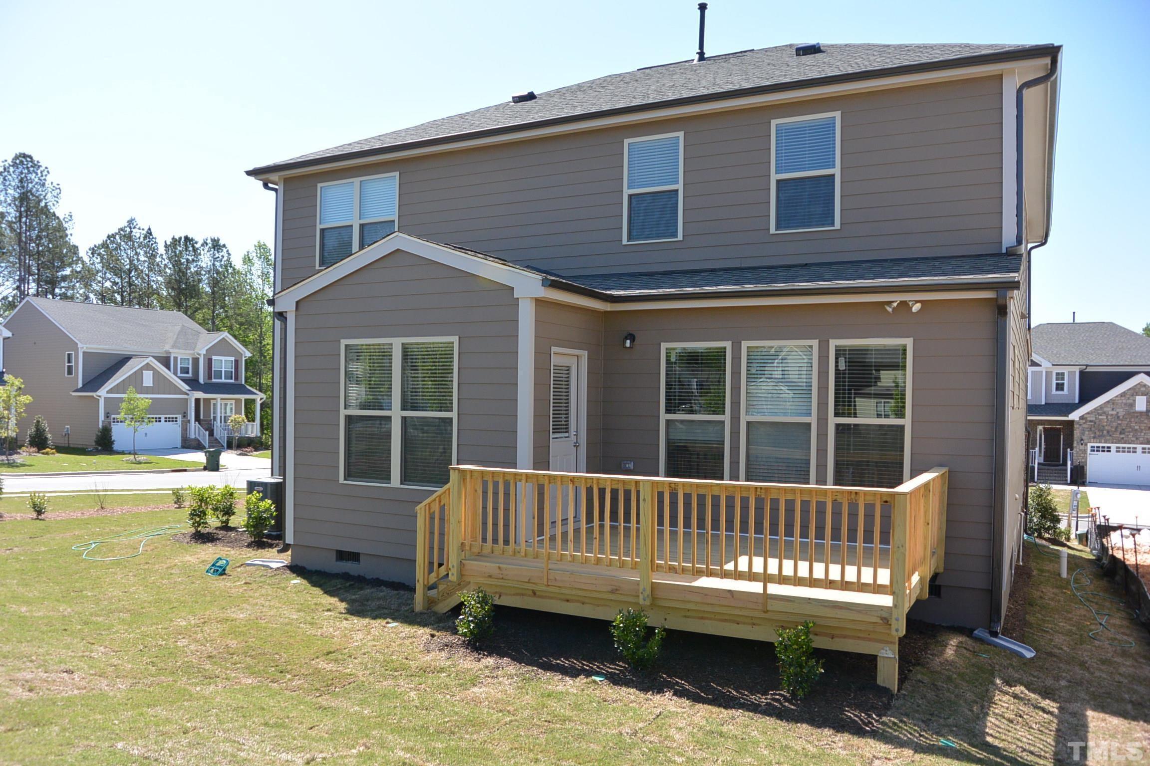 249 Tilth Street Cary, NC 27519 - Photo 4 of 18 a view of a house with a wooden deck and a yard
