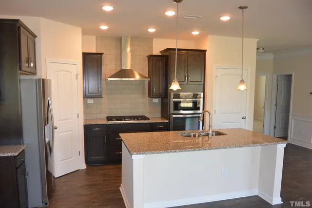 a kitchen with stainless steel appliances granite countertop a refrigerator and a sink