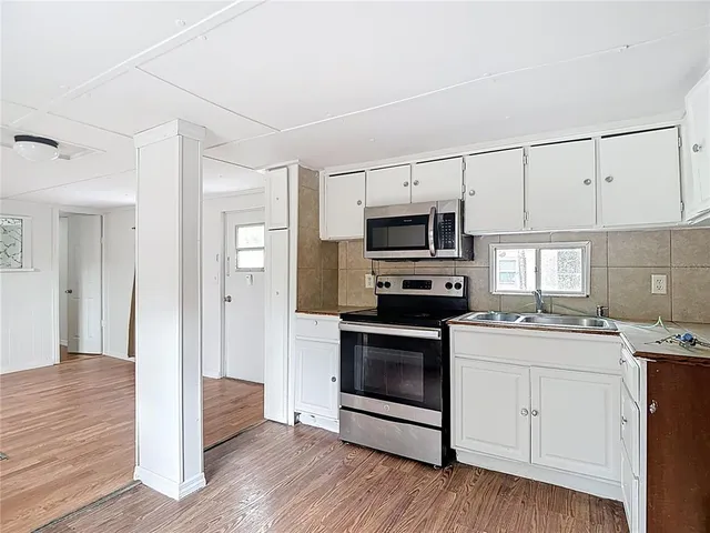 a kitchen with a sink stove and microwave