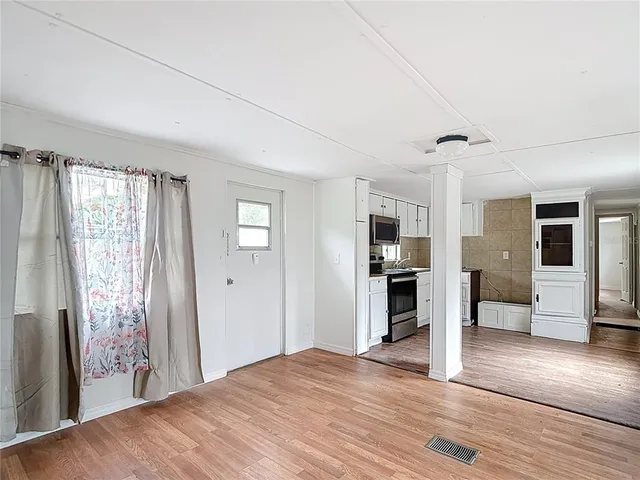 a view of a livingroom with wooden floor and window