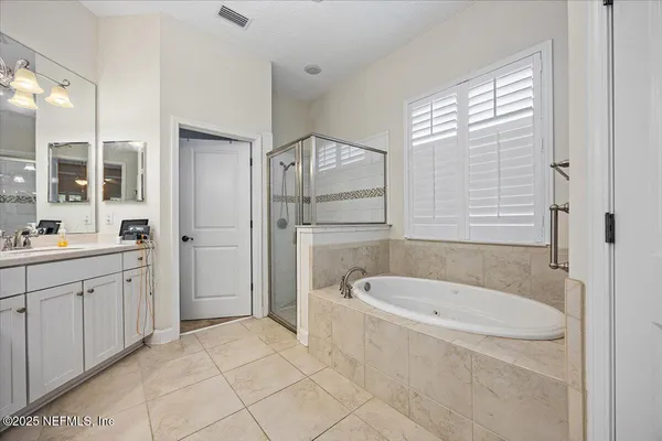 a bathroom with a tub a sink and a large mirror