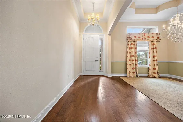 a view of a room with wooden floor staircase and a hallway