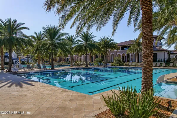 a view of a swimming pool with a garden and patio
